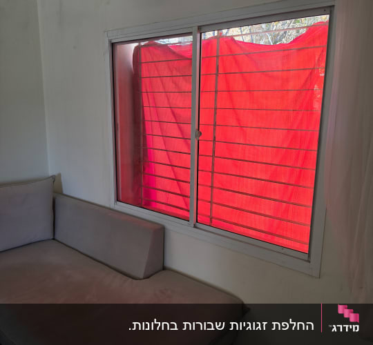 חלון הזזה בעל מסגרת אלומיניום לבנה וזכוכית בחדר מגורים